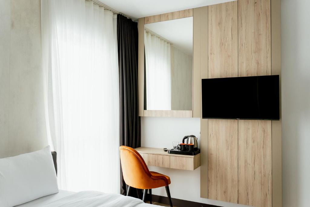 um quarto com uma cama, uma televisão e uma cadeira em Lamede em Wiener Neustadt