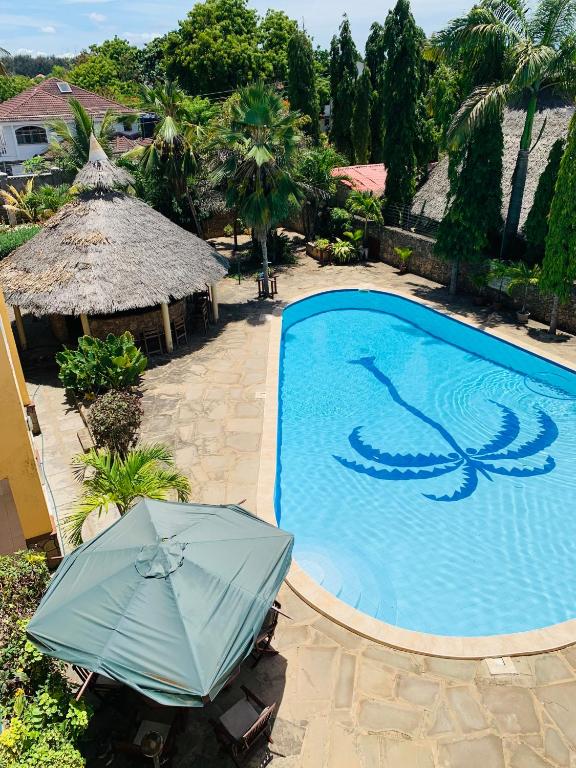 a swimming pool with an umbrella next to a resort at Ltorec in Nyali