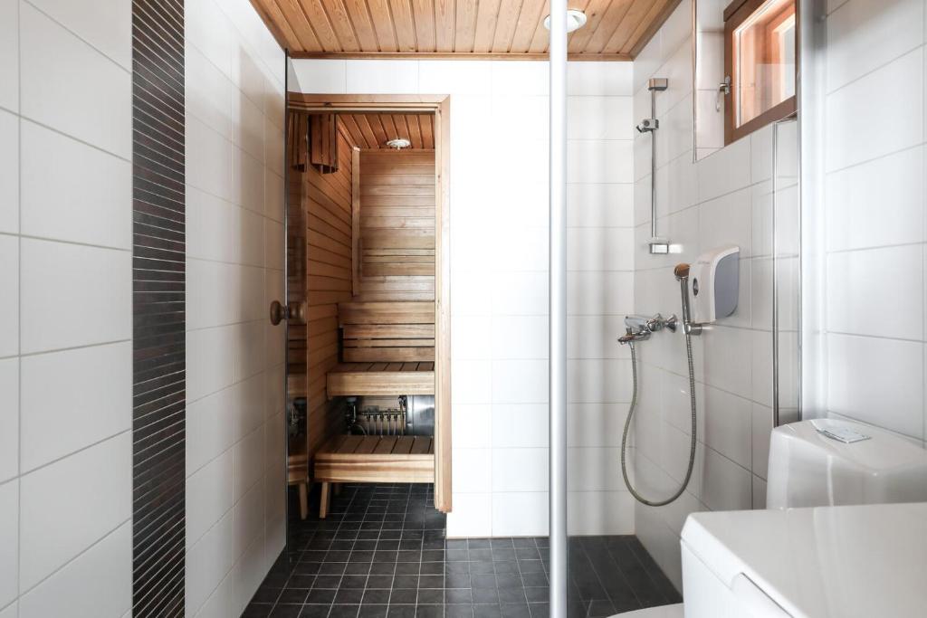 uma casa de banho com uma cabina de duche ao nível do chão e um WC. em Himos Mökki superior - Chalet Cottage superior ski-in-ski-out em Jämsä