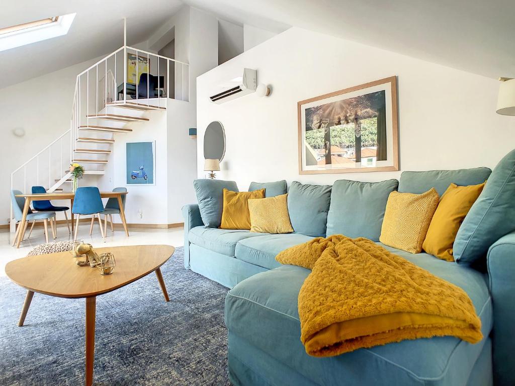 ein Wohnzimmer mit einem blauen Sofa und einem Tisch in der Unterkunft Canto Idílico by LovelyStay in Funchal