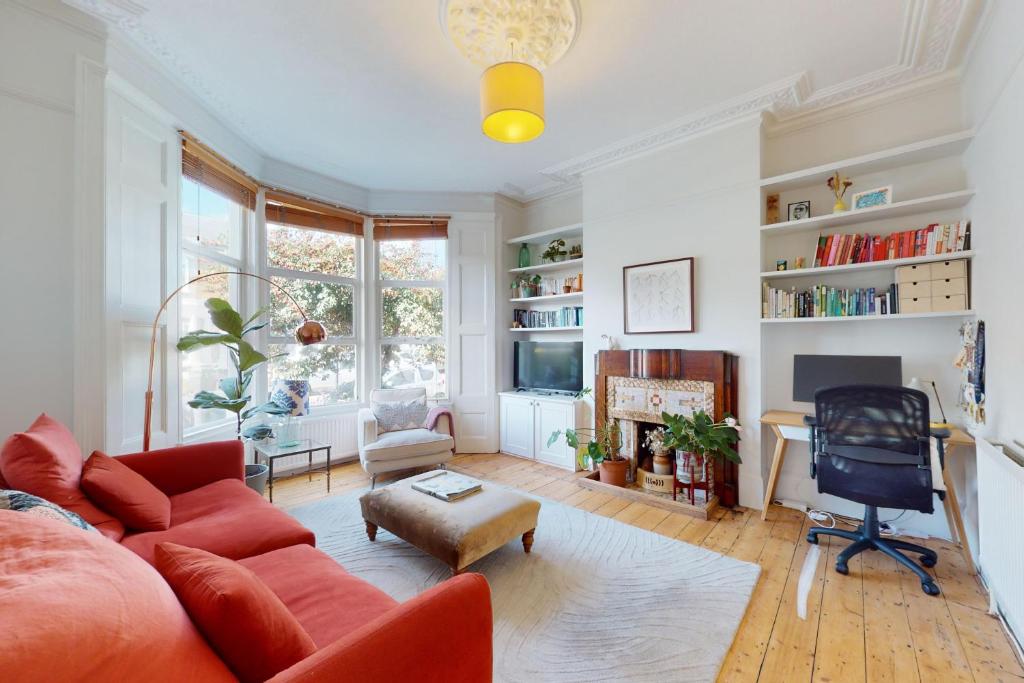 a living room with a red couch and a chair at Charming 1 bedroom apartment in Finsbury Park in London