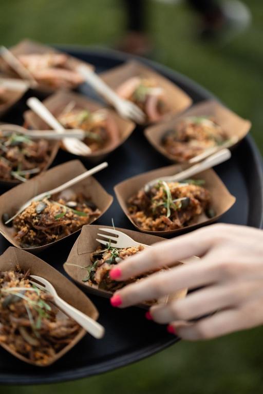 a person holding a plate of food with chopsticks at Hotel Bohinj in Bohinj