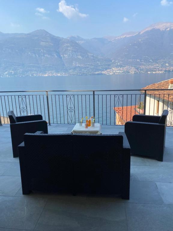 einen Tisch und Stühle auf einem Balkon mit Blick auf das Wasser in der Unterkunft Gere house in Lezzeno