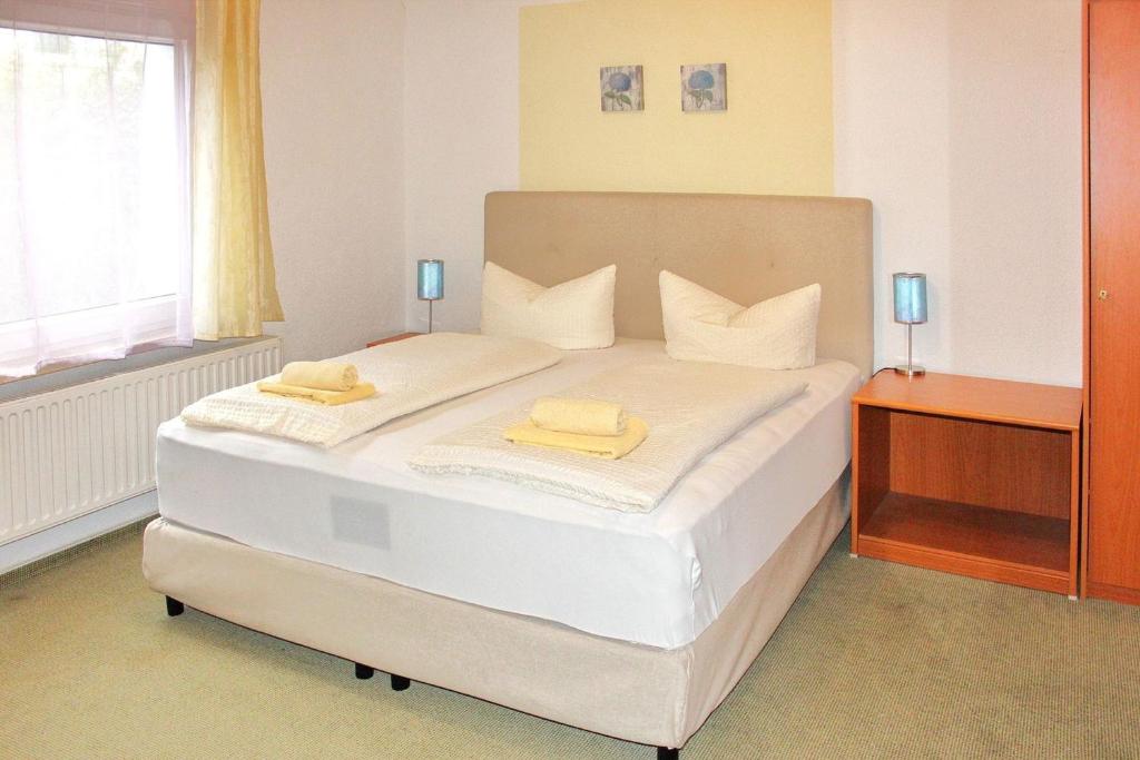 a bedroom with a bed with two yellow towels on it at Pension An der Kamske, DZ 3 in Lübbenau