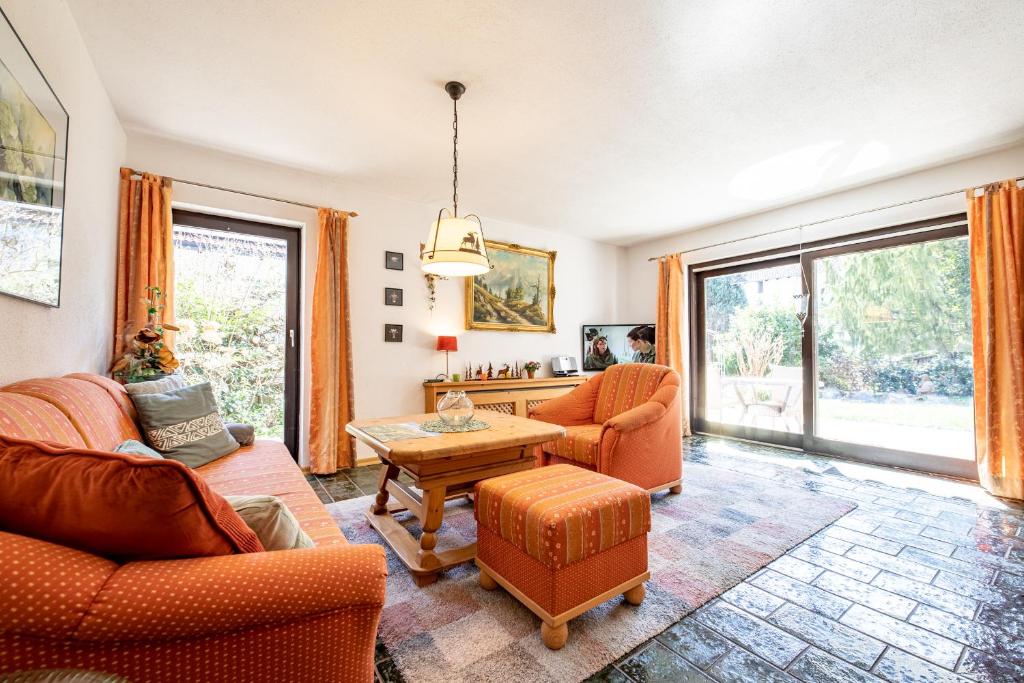 een woonkamer met oranje meubels en een tafel bij Bergrose in Farchant