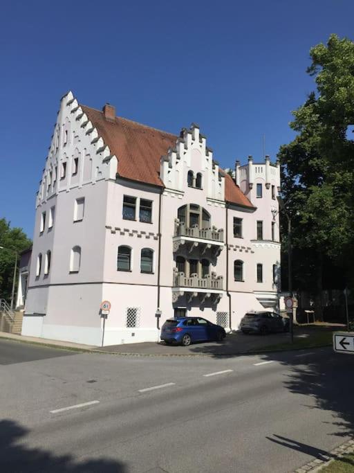 a large white building with a car parked in front of it at Ferienwohnung in historischer Villa mit Gartennutzung in Furth im Wald
