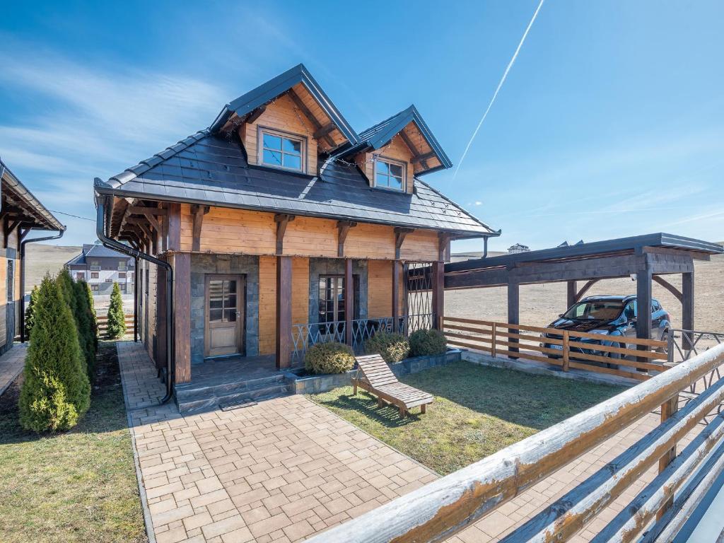 a wooden house with a bench in front of it at Velika Recepcija 10 in Zlatibor