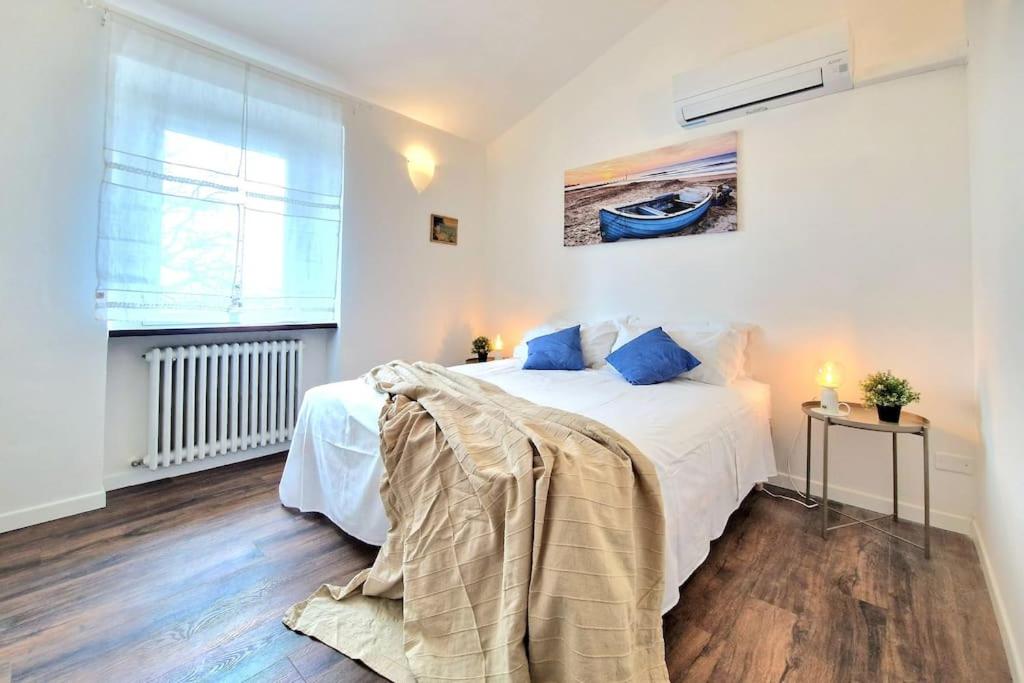 een slaapkamer met een groot wit bed met blauwe kussens bij [Idromassaggio & BBQ]wifi, relax e private parking in Sirolo