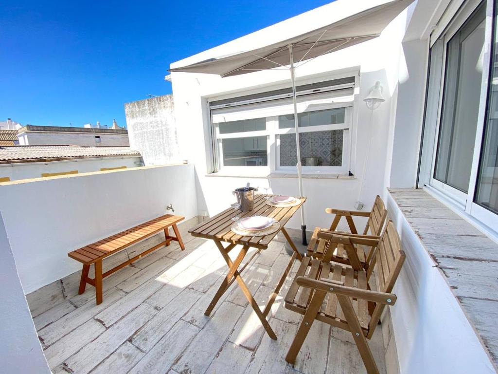 a patio with two chairs and a table on a balcony at Buhardilla en calle Ancha, pleno centro in Sanlúcar de Barrameda