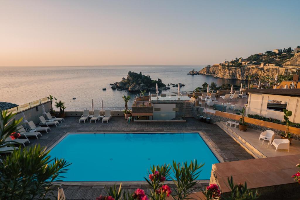 a swimming pool with a view of the ocean at Taormina Panoramic Hotel in Taormina