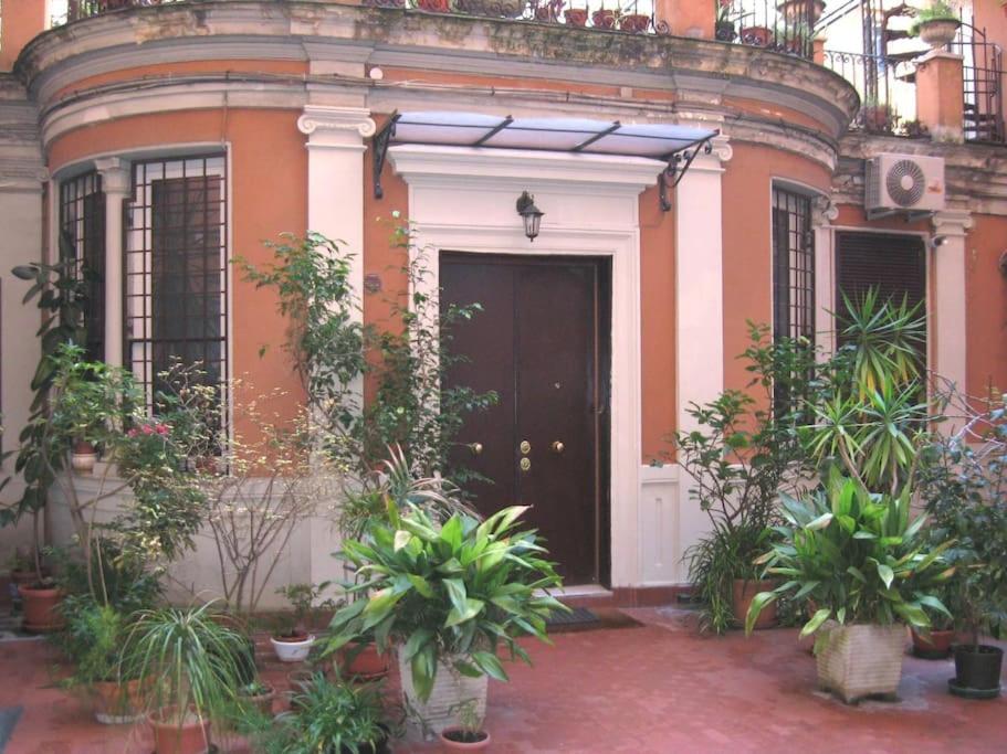 dom z czarnymi drzwiami i kupą roślin w obiekcie OPERA THEATER APARTMENT - ROMA CENTER w Rzymie