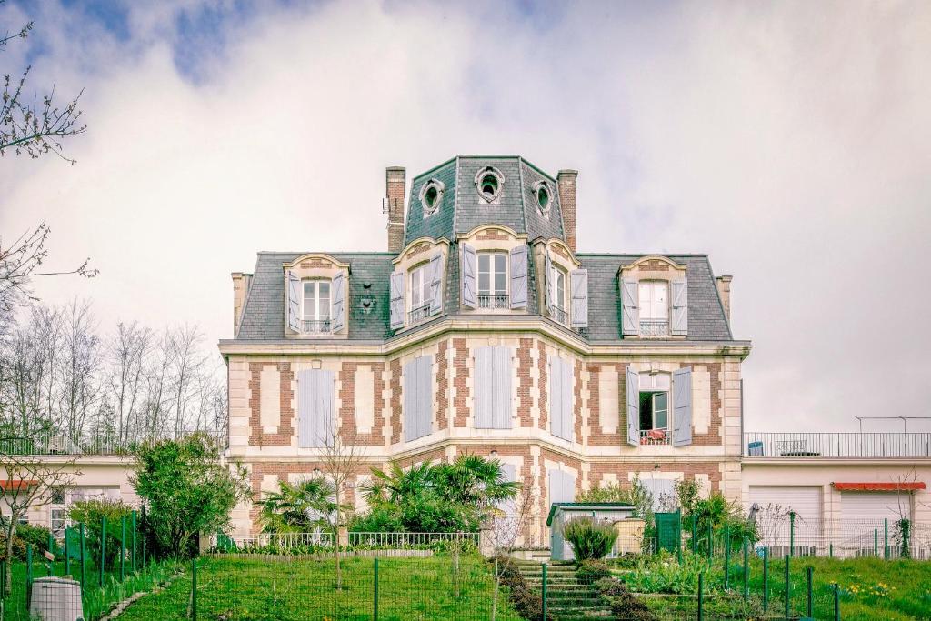 ein altes Haus mit einem Turm darüber in der Unterkunft Le Bateau Perché - Bel appt pour 4 in Nay