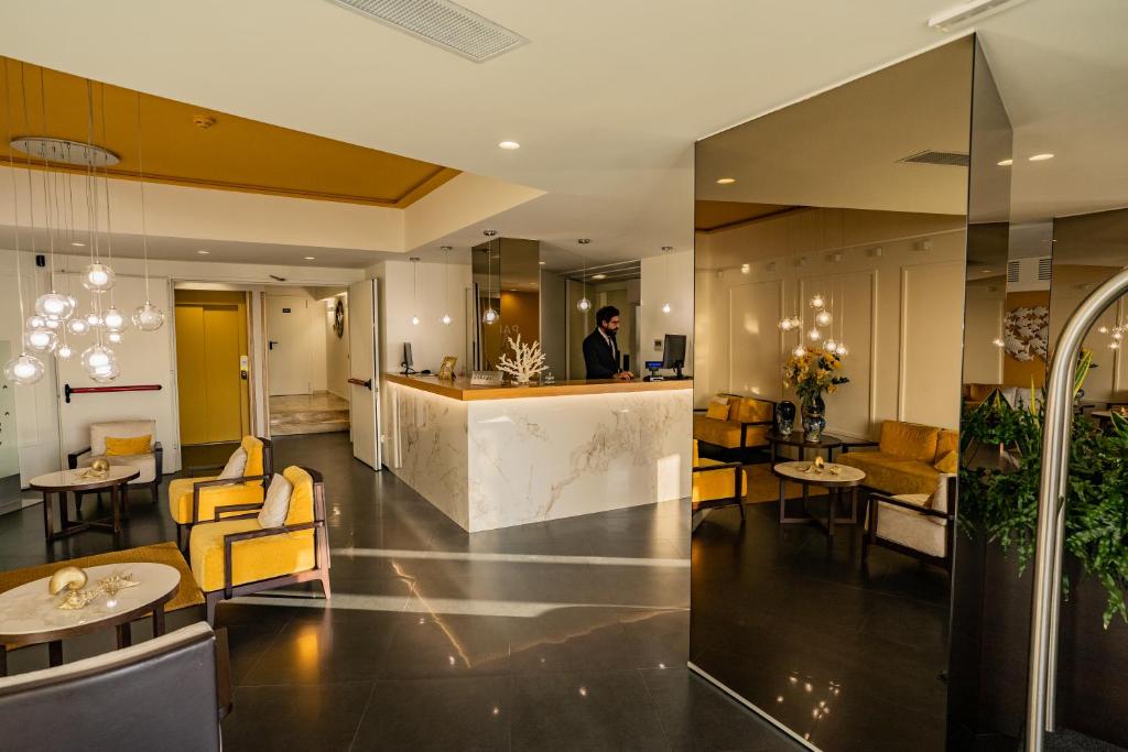 a man standing at a counter in a hotel lobby at Taormina Panoramic Hotel in Taormina