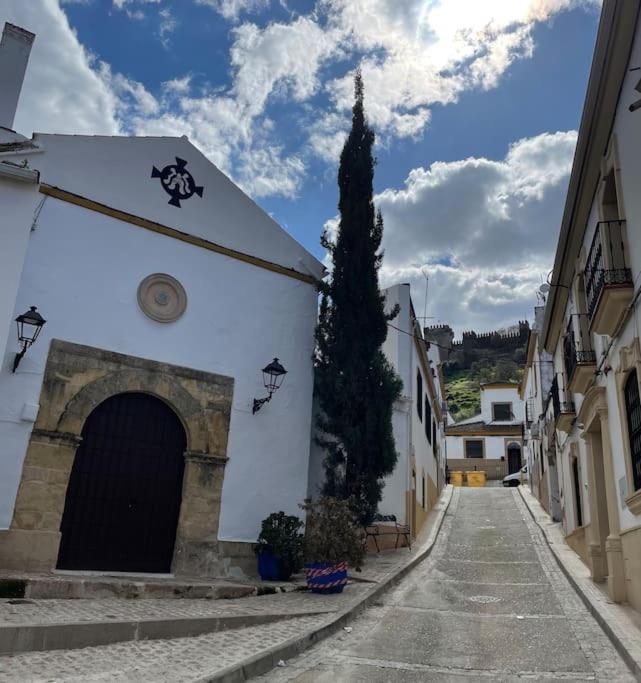 um edifício com uma árvore no meio de uma rua em Apartamento El convento em Almodóvar del Río