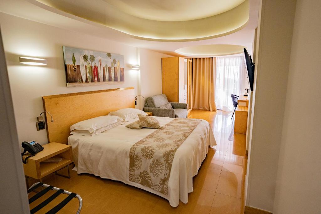 a bedroom with a bed and a living room at Taormina Panoramic Hotel in Taormina