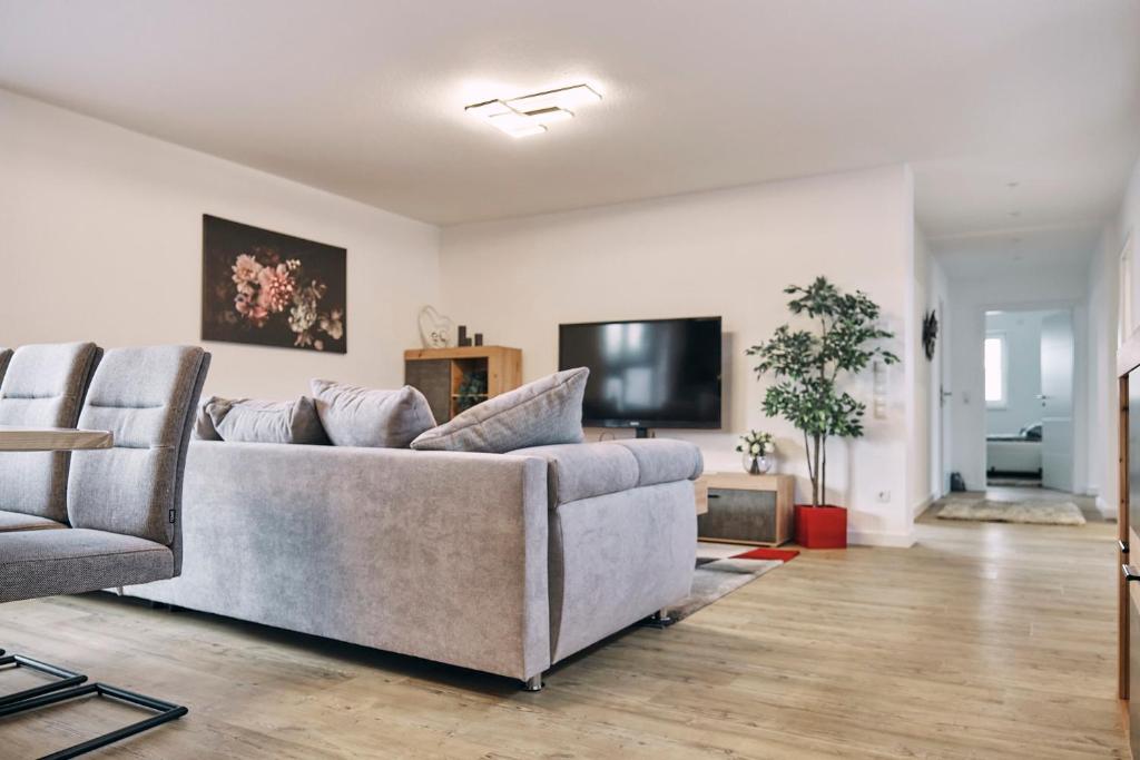 uma sala de estar com um sofá e uma televisão de ecrã plano em Harener Hafentraum- 90qm Wohnung mit 40qmTerrasse-kostenloses parken- nähe Schloss Dankern em Haren