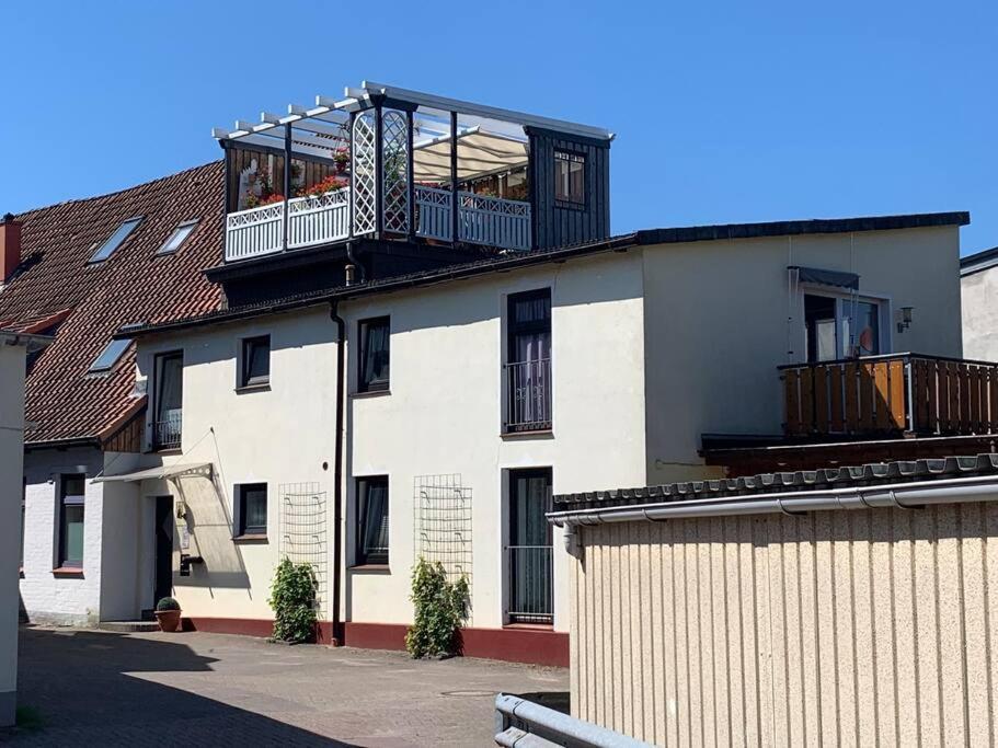 a white building with a balcony on top of it at Über den Dächern der Stadt in Bremervörde