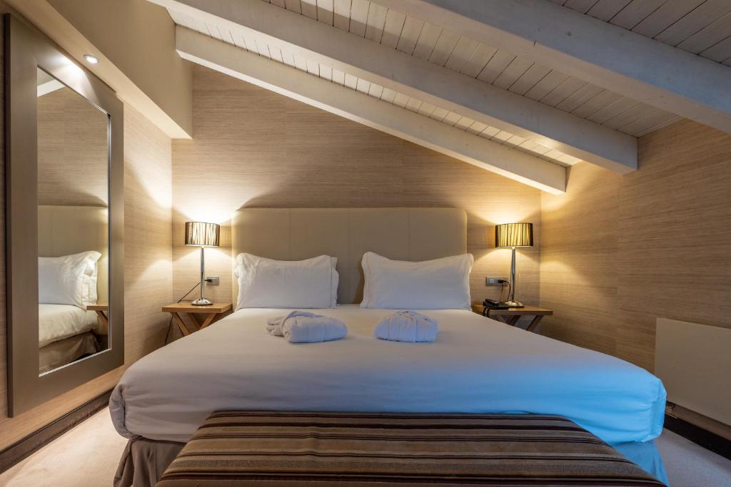 a bedroom with a large white bed with two pillows at Hotel La Trufa Negra in Mora de Rubielos