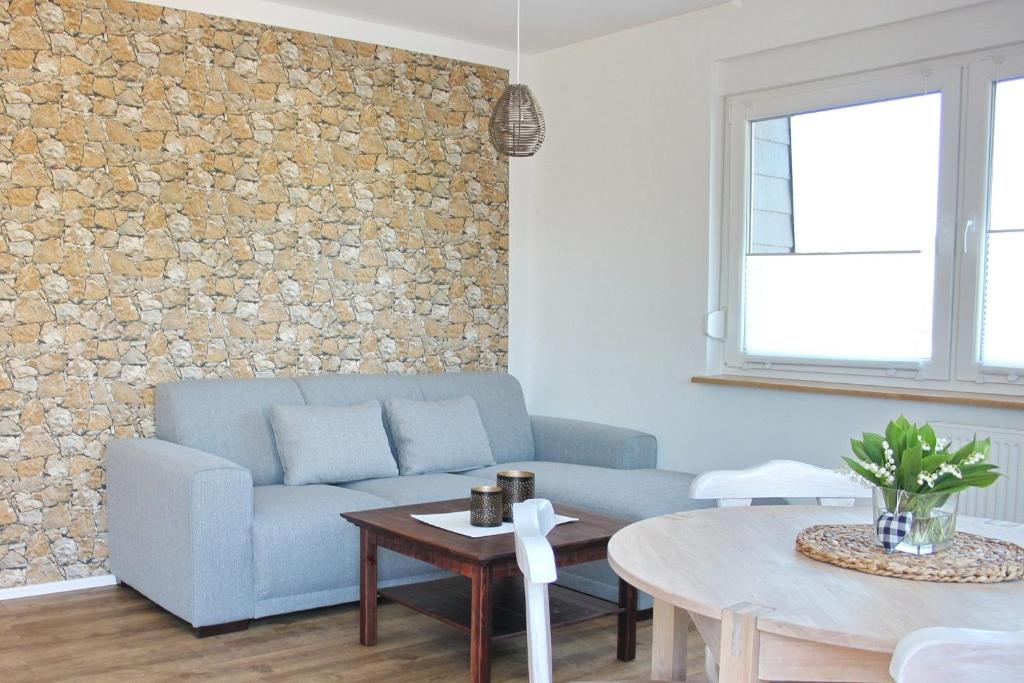 a living room with a blue couch and a stone wall at Ferienwohnung Lischka in Lübbenau