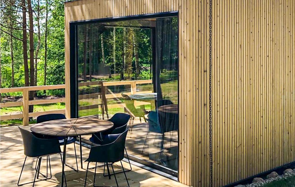 a patio with a table and chairs and a glass wall at Amazing Home In Rydzewo With Sauna in Rydzewo