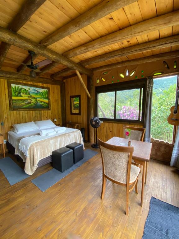 1 dormitorio con cama y techo de madera en Cabana com vista para o canyon, en Praia Grande