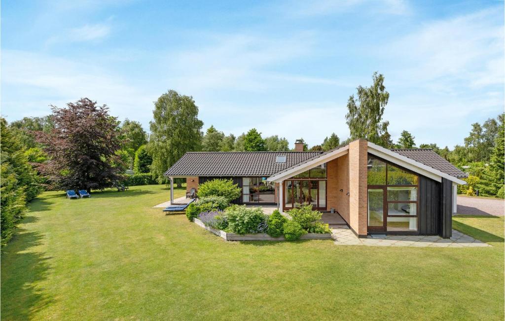una casa con un gran patio con una casa en Amazing Home In Vggerlse With Indoor Swimming Pool, en Bøtø By
