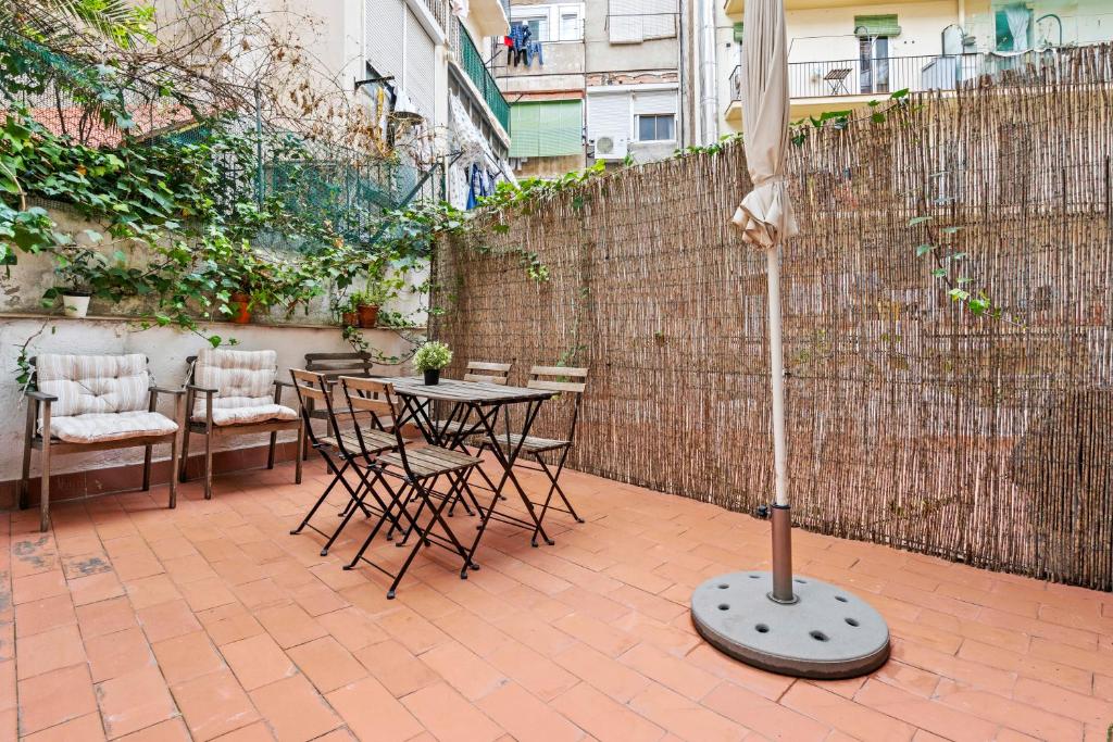 an umbrella on a patio with a table and chairs at Flateli Fabra in Barcelona