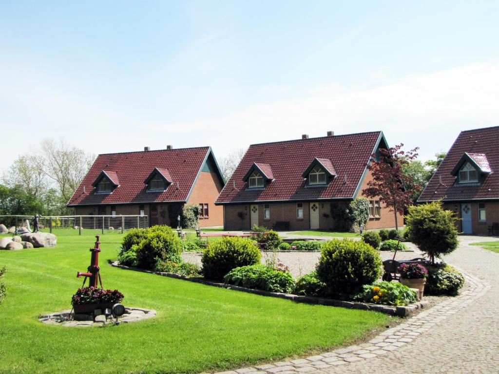 una fila de casas con césped verde en Ferienanlage Margaretenhof, en Neujellingsdorf