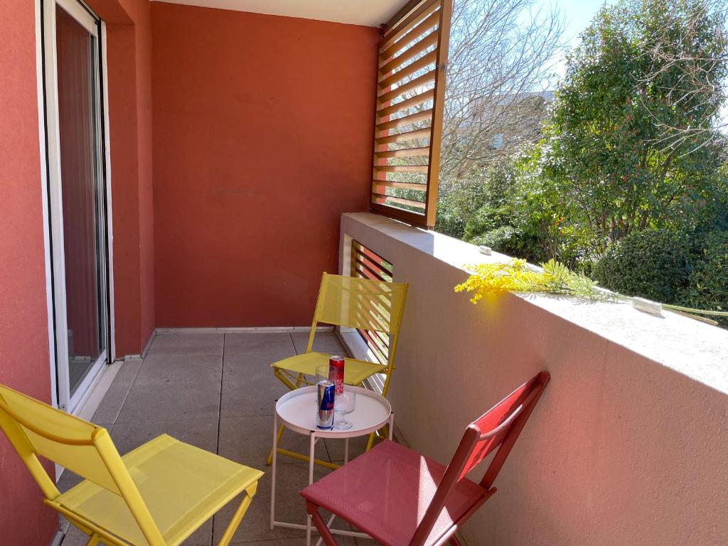 un patio con sillas, una mesa y una ventana en Le Nomade, Parc Montcalm et stationnement privé, en Montpellier
