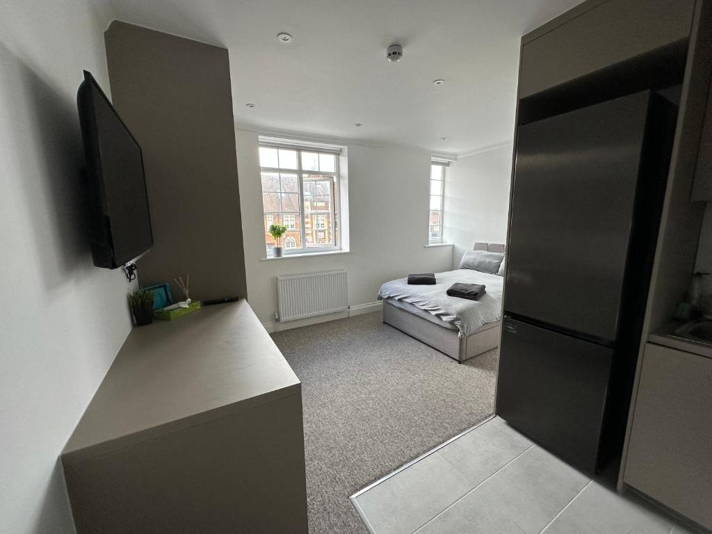 ein Wohnzimmer mit einem TV und einem Sofa in der Unterkunft Spectacular Modern, Brand-New, 1 Bed Flat, 15 Mins Away From Central London in Hendon