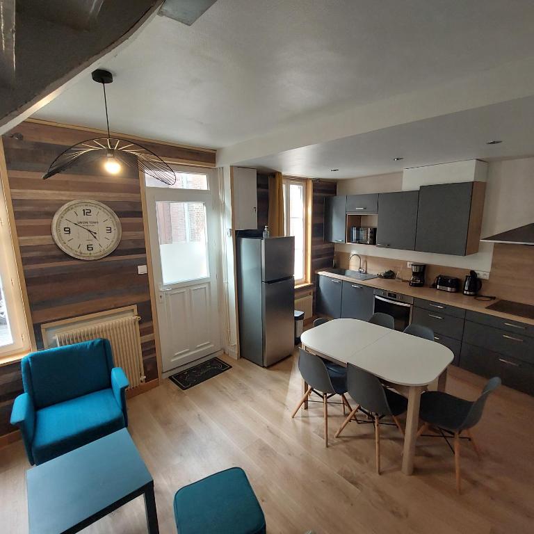 une cuisine avec une table, des chaises et une horloge dans l'établissement Le chant des mouettes a 300 m de la mer et du port, à Fécamp