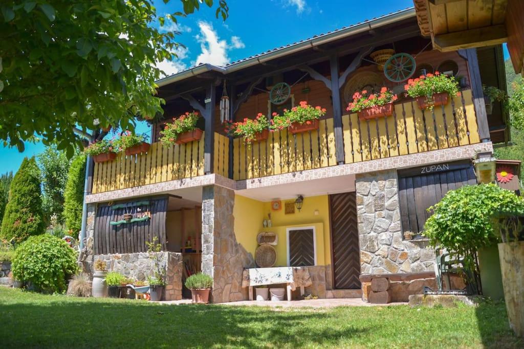 una casa con un balcón con flores. en Romantic Cottage In Real Nature en Radeče