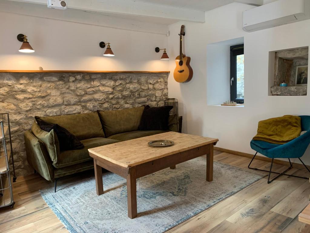 a living room with a couch and a table at Charming typical stone house with modern amenities in Chauzon