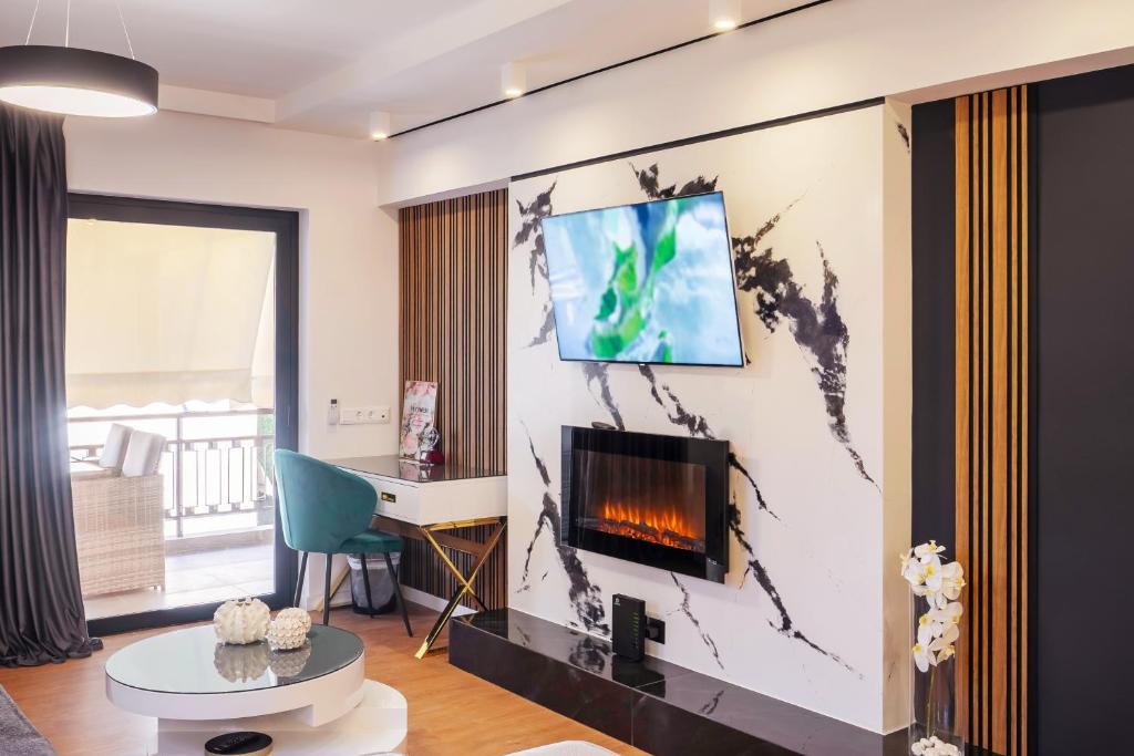 a living room with a fireplace and a tv on a wall at EcoStay - Infinity business class 2BDR apartment by the sea in Alimos in Athens