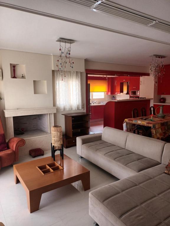 uma sala de estar com um sofá e uma mesa em Glamour beautique villa em Acharnae