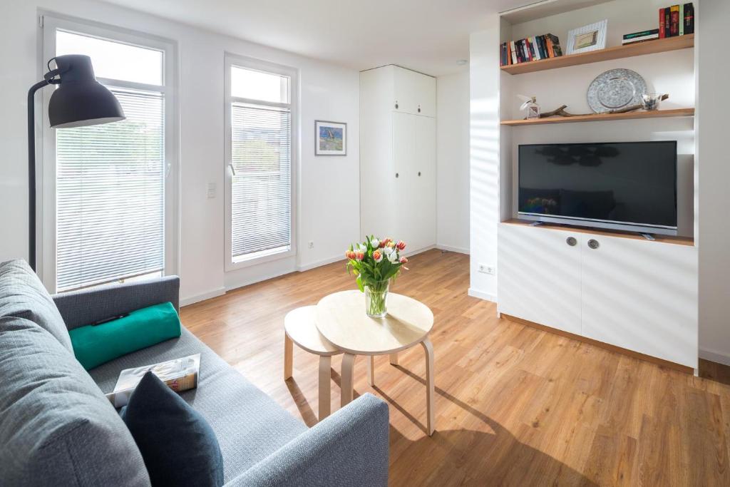 a living room with a couch and a table with flowers at John Silver in Norderney