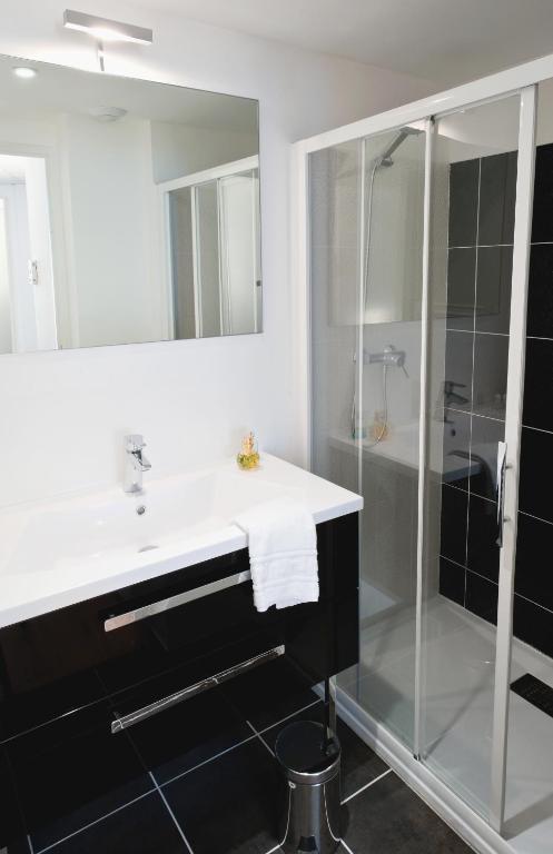a bathroom with a sink and a shower at Ténéo Apparthotel Talence Arthena in Talence