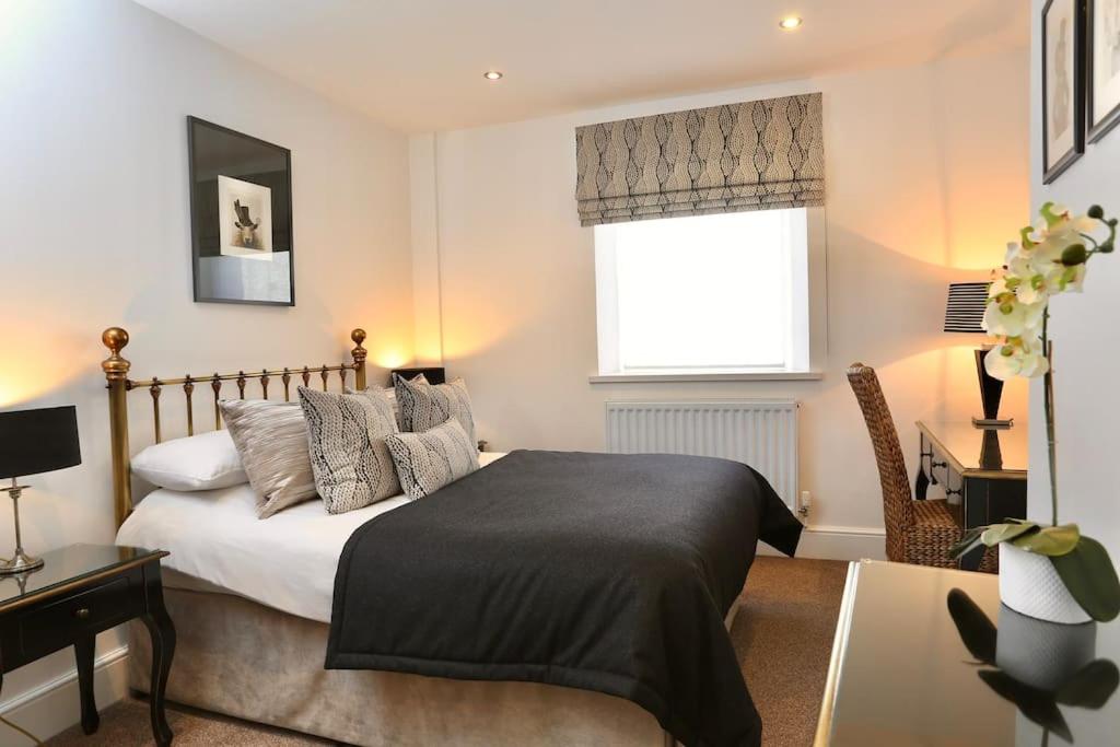 a bedroom with a bed and a desk and a window at 8 Standard Street by The Bear Hotel Crickhowell in Crickhowell