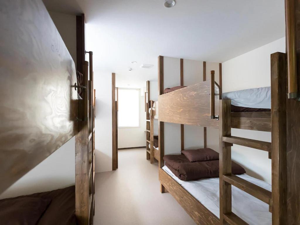 een kamer met 3 stapelbedden en een hal bij Osaka Namba Hostel MIYABI in Osaka