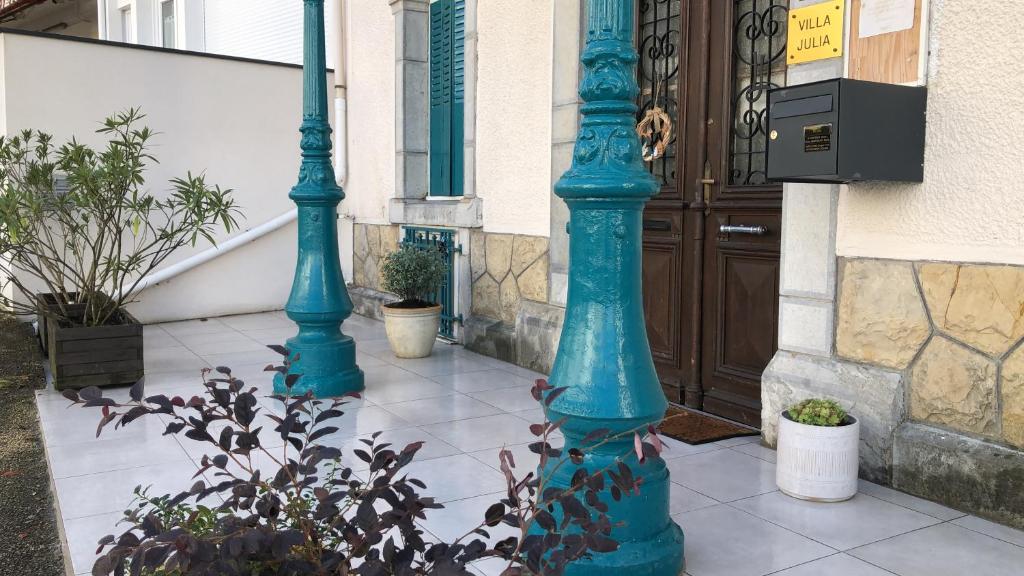 twee turquoise palen op een stoep voor een gebouw bij Villa Julia in Capvern