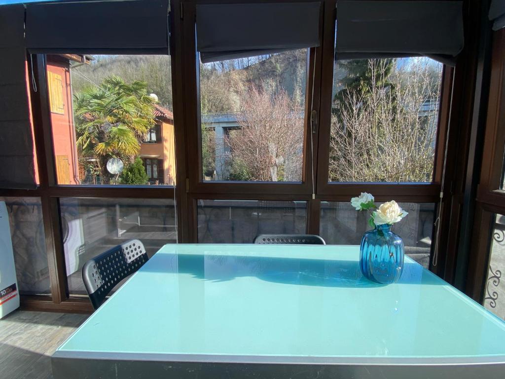 een blauwe vaas op een tafel in een kamer met ramen bij Alloggio Sassi in Turijn