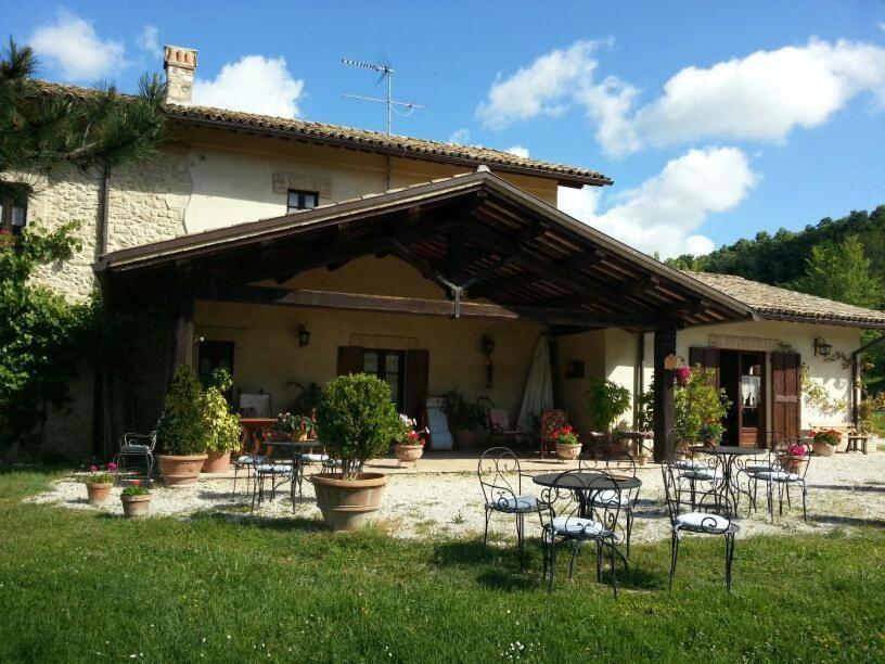 a group of chairs and tables in front of a house at Agriturismo Santa Giusta in Poggio San Lorenzo
