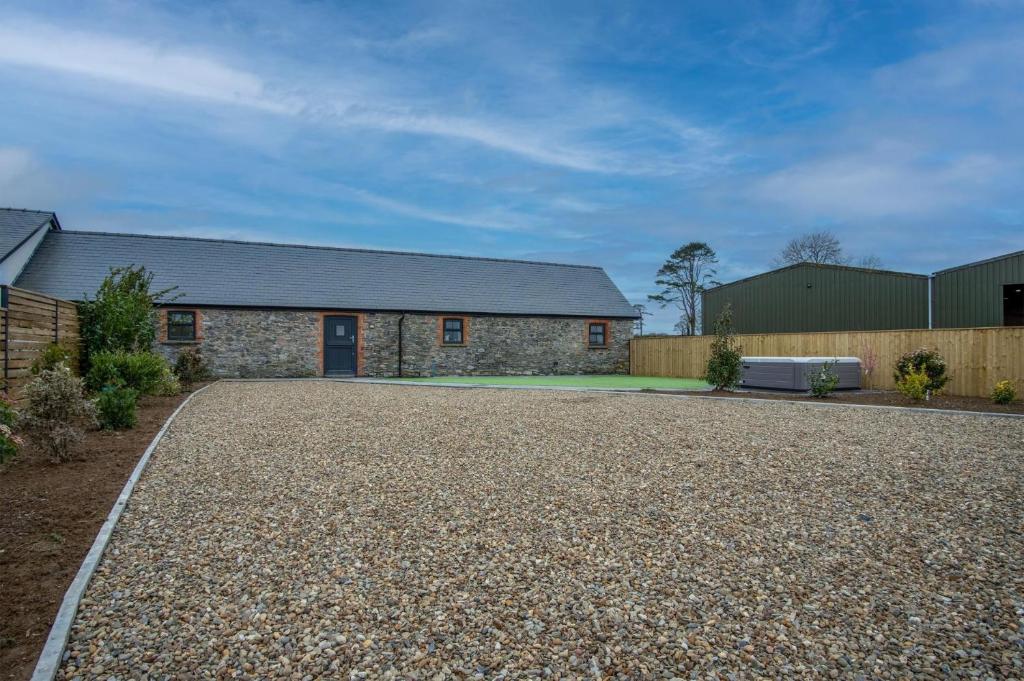 a house with a gravel driveway in front of it at The Barn At Kiln Park - 2 Bed Cottage - Narberth in Narberth
