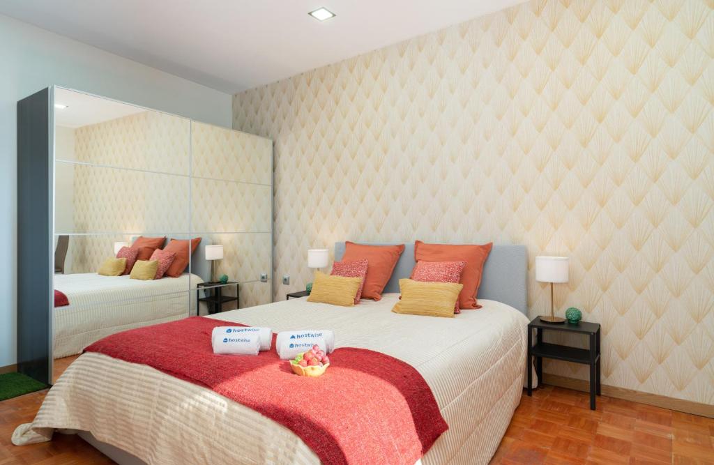 a bedroom with a large bed with red and yellow pillows at Magnificent Sunny Flat - Douro River in Vila Nova de Gaia