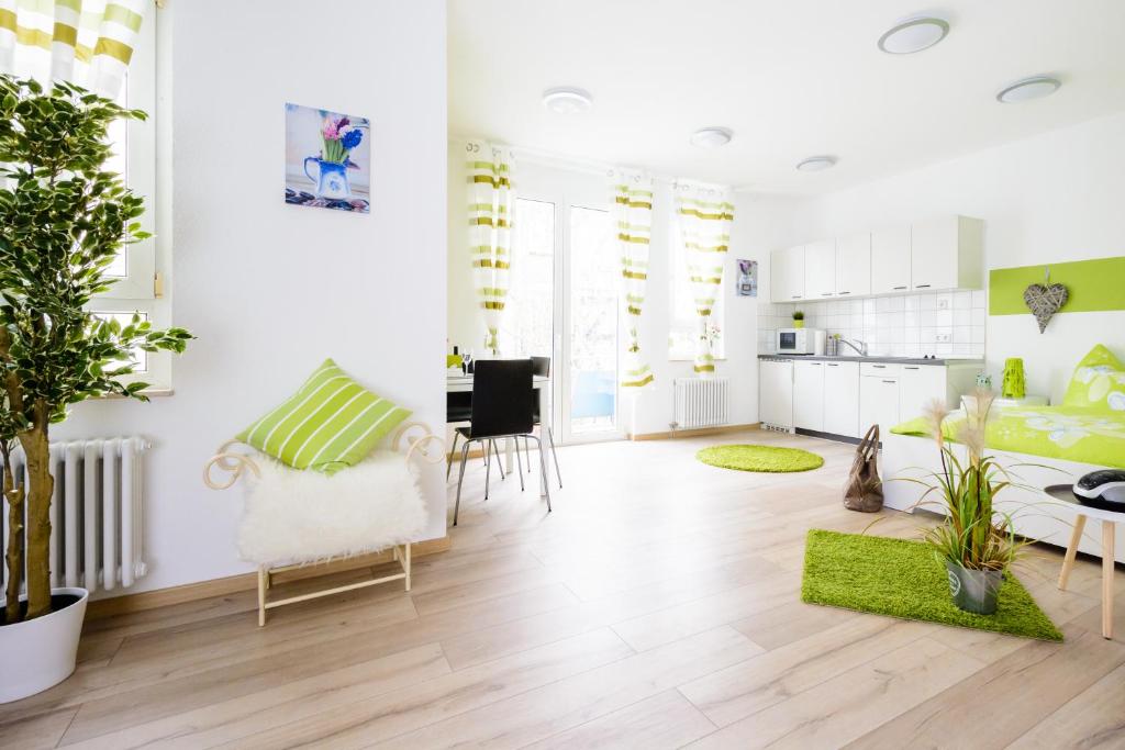 a living room with white walls and green accents at Breisach City-Appartements in Breisach am Rhein