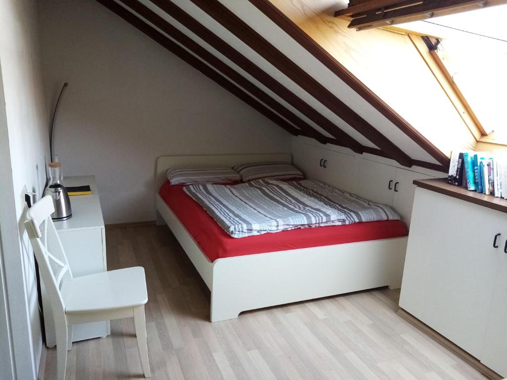 a small bedroom with a bed and a chair at Casa Libra in Düsseldorf