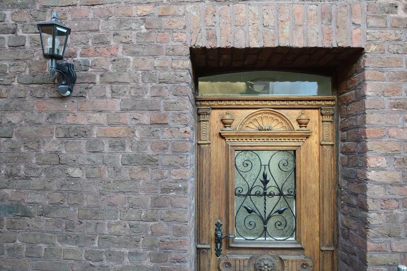 a wooden door in a brick wall with a window at Altes Pastorat in Kevelaer
