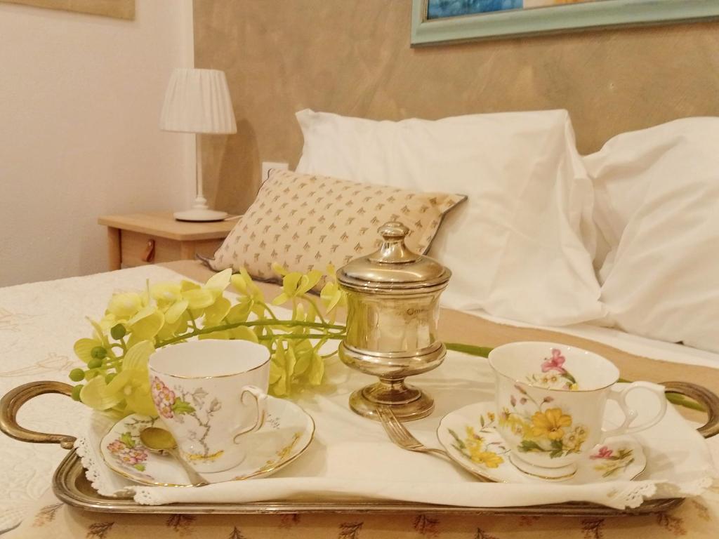 a tray with two cups and a tea set on a bed at COVO DI LEVANTE in La Spezia