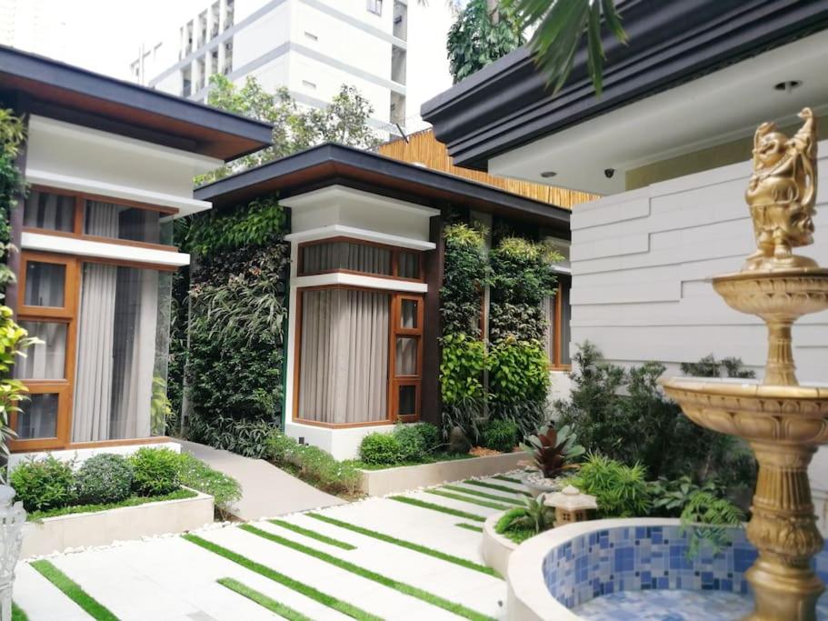 una casa con una fuente frente a ella en Adria Residences - Emerald Garden - 2 Bedroom Unit for 4 person, en Manila