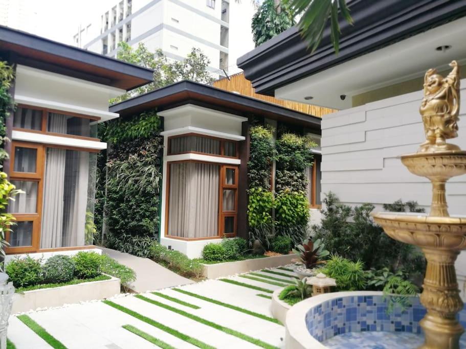 a house with a fountain in front of it at Adria Residences - Emerald Garden - 2 Bedroom Unit for 4 person in Manila